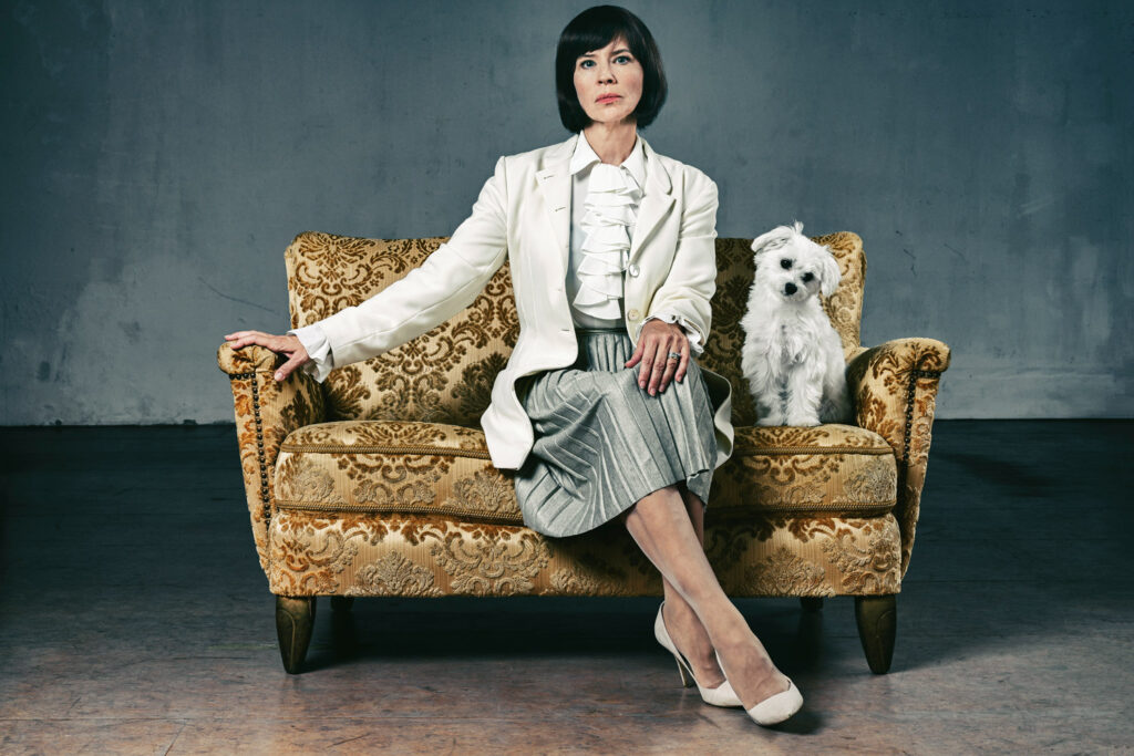 Die Geizige: Hauptdarstellerin auf Sofa mit Hund