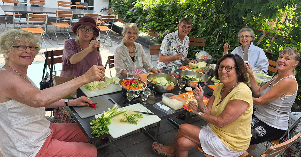 Helfer:innen beim Gemüserüsten für die feine Paella